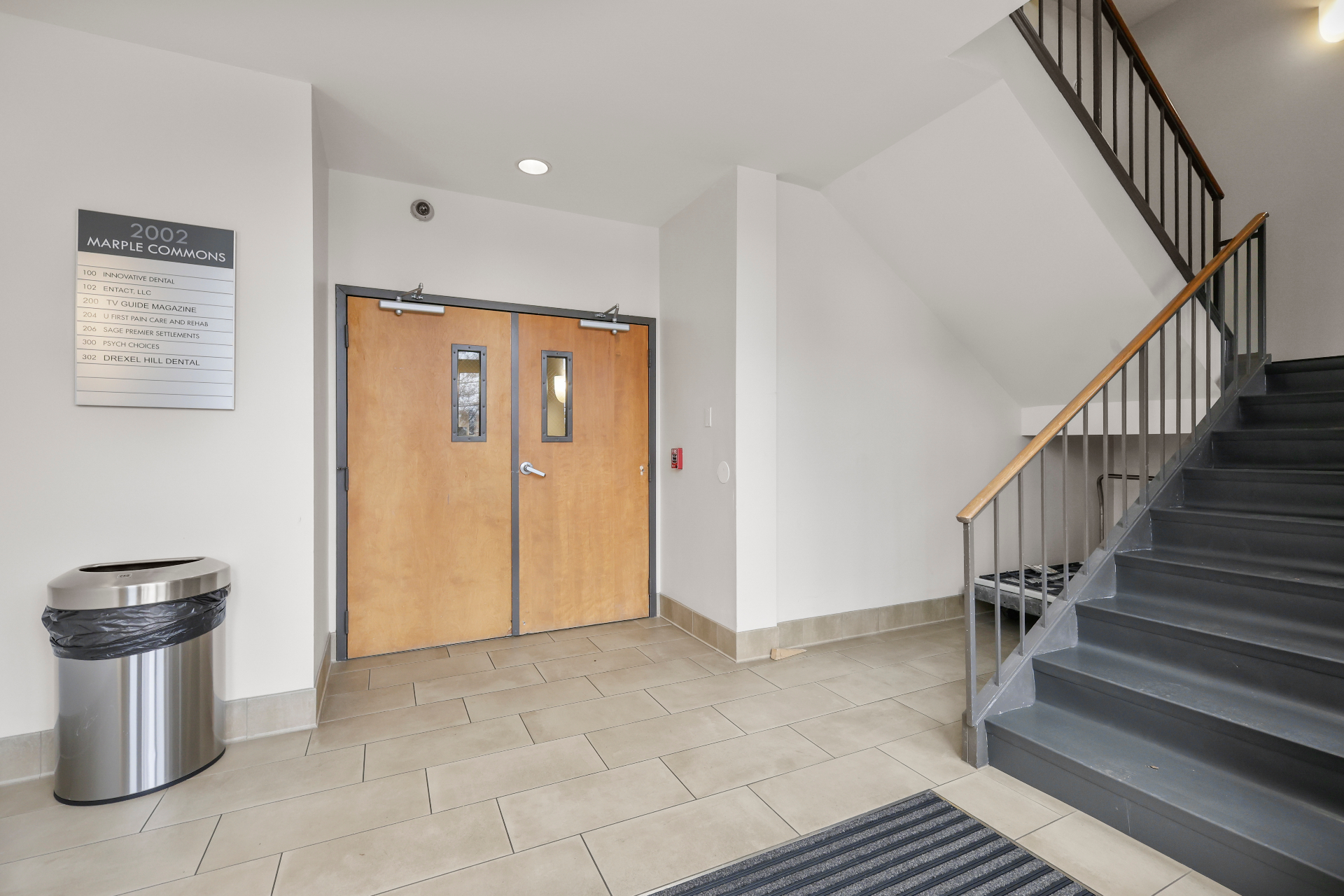 Refurbished office lobby with stairwell and wood detailing by JST Construction Group
